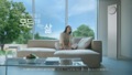 소파에 앉은 사람과 그 옆의 LG 휘센 타워에어컨